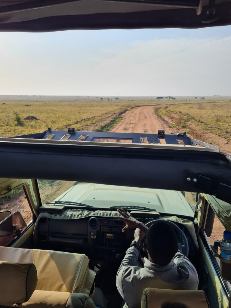 Mandela, guide de safari, dans sa Jeep sur une route du parc de Serengeti en Tanzanie.