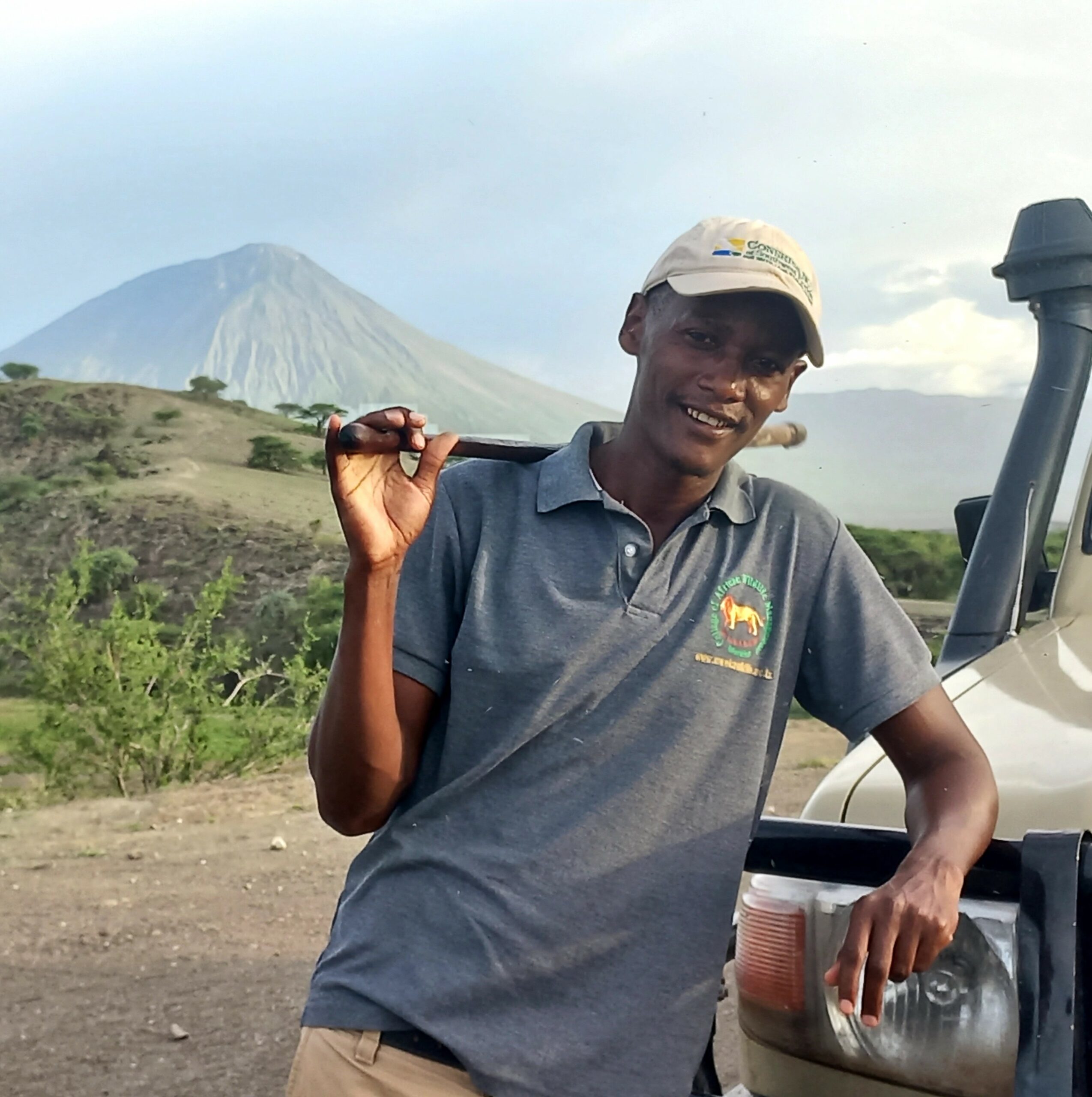 Mandela, guide de safari maasai en Tanzanie, avec sa Jeep devant le Ol Doinyo Lengaï.