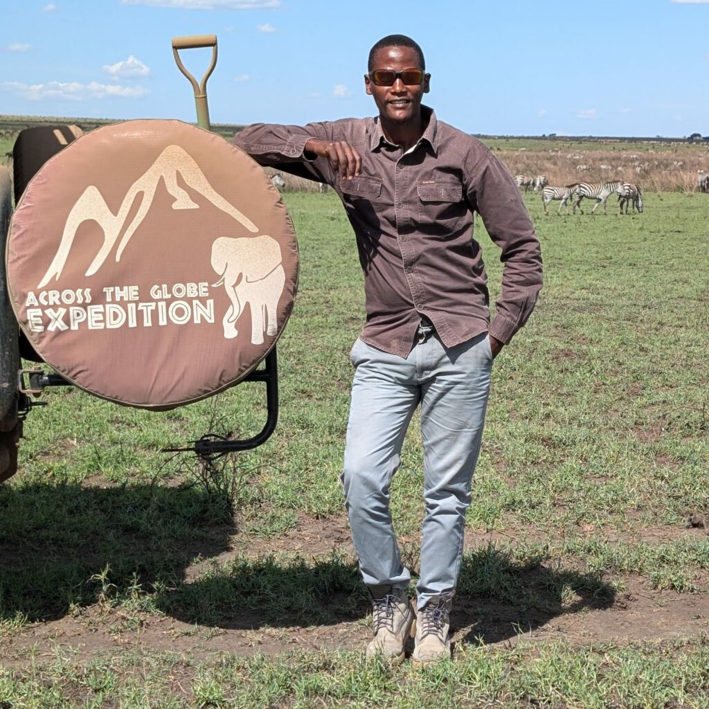 Mandela, guide de safari maasai en Tanzanie, avec sa Jeep devant le Ol Doinyo Lengaï.